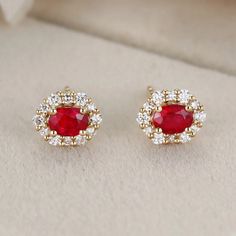 These 18K Yellow Gold Oval Ruby Stud Earrings with a Lab Diamond Halo are the perfect addition to any jewelry collection. Luxury Oval Ruby Earrings, Red Oval Diamond Earrings For Anniversary, Oval Red Diamond Earrings For Anniversary, Elegant Red Oval Diamond Earrings, Luxury 14k Gold Oval Earrings, Luxury Oval Cluster Earrings For Anniversary, Elegant Oval Cluster Earrings For Anniversary, Exquisite Yellow Gold Earrings With Halo Design, Exquisite Yellow Gold Halo Earrings