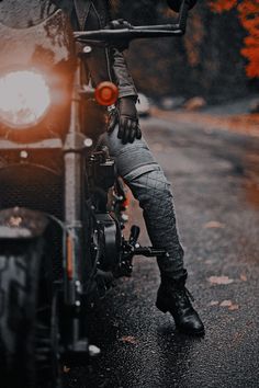 a person sitting on a motorcycle with their feet propped up in the front wheel area