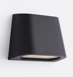 a black wall light on a white wall