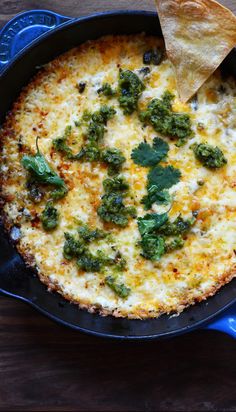 a tortilla dish with spinach and cheese in a cast iron skillet