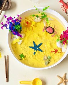 a bowl filled with yellow food next to some sea animals and starfish on the table