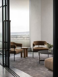 a living room filled with furniture and a large window overlooking the cityscape in the distance