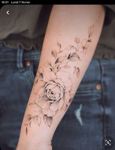 a woman's arm with a flower tattoo on the left side of her arm