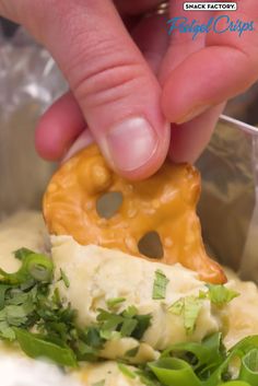 a person dipping some food into a container