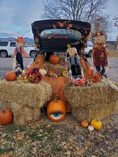 hay bales stacked on top of each other with scarecrows and pumpkins