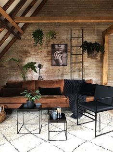 a living room with exposed brick walls and wooden beams, leather couches and chairs