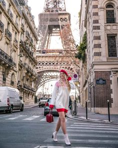 a woman crossing the street in front of the eiffel tower