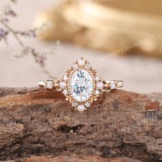 a close up of a ring on a piece of wood with flowers in the background