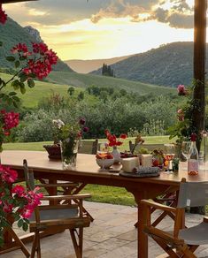 a wooden table with flowers on it in front of mountains