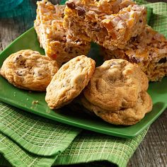 a green plate topped with cookies and muffins