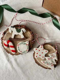 two christmas ornaments are hanging from twine