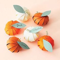 four origami pumpkins with name tags on them