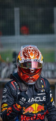 a man wearing a red bull racing suit and helmet