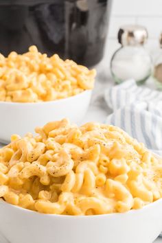 two white bowls filled with macaroni and cheese