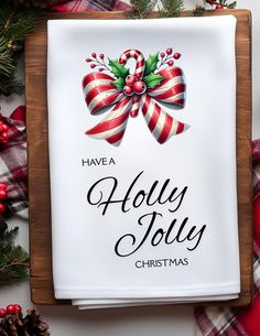 a wooden sign with holly jollys on it next to christmas decorations and pine cones