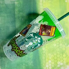 a starbucks cup with a straw in it sitting on top of a green and yellow background