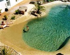 an aerial view of people swimming in the water at a tropical beach area with palm trees