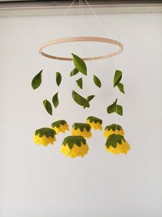 a yellow flower is hanging from a circular wooden chandelier with green leaves on it