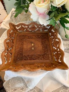 a wooden tray sitting on top of a table next to flowers