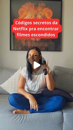 a woman sitting on top of a couch holding a microphone in front of her face