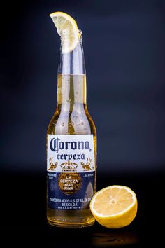 a bottle of corona beer next to a sliced lemon