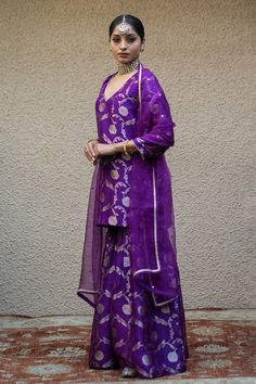 Purple three fourth sleeves V neck Banarasi kora silk kurta with woven Bahar details. Paired with a matching gathered flare sharara and a mukaish butti embellished dupatta. - Aza Fashions Designer Purple Art Silk Sharara, Purple Sharara For Transitional Season, Silk Sharara With Gota Work And Long Sleeves, Silk Long Sleeve Sharara With Gota Work, Transitional Designer Silk Palazzo Set, Purple Silk Palazzo Set For Festivals, Festive Purple Raw Silk Sharara, Festival Silk Purple Palazzo Set, Elegant Purple Palazzo Set For Festivals