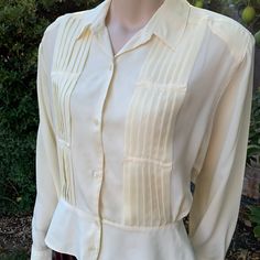 This is a great quality cream colored pleated blouse from the 80s-90s. This button up was made by Silvercord Material is 100% Polyester  It is on the thinner side and it does have shoulder pads (which can always be easily removed) Tag size is 12  Please look over actual measurements since this is vintage  No stains or flaws or holes and great quality! Measurements as follows: Pit to pit laying flat is 22" inches  Waist is 15" laying flat  Length is 23" inches  I ship priority mail with tracking! Classic Pleated Collared Blouse, Fitted Pleated Button-up Top, Classic Pleated Button-up Top, Classic Pleated Collared Tops, Classic Collared Pleated Top, Cream Retro Blouse For Formal Occasions, Retro Cream Blouse For Formal Occasions, Cream Retro Button-up Top, Retro Cream Button-up Tops