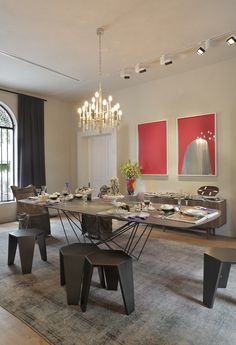 a large dining room table and chairs with chandelier in the background, along with an area rug on the floor