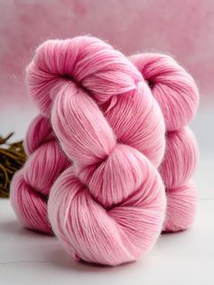 two skeins of pink yarn sitting next to each other