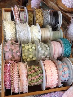 many different colored ribbons are on display in a box with ribbon spools next to each other