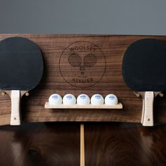 two ping pong paddles on top of a wooden rack