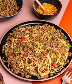 a pan filled with noodles and vegetables on top of a table