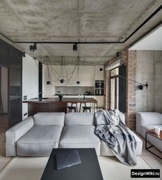 a living room filled with furniture next to a kitchen and dining area in the background