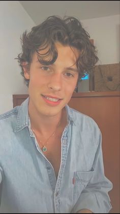 a man with curly hair wearing a blue shirt