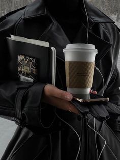 a woman holding a cup of coffee and cell phone