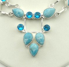 "Larimar, also called \"Stefilia's Stone\", is a rare blue variety of pectolite found only in the Dominican Republic, in the Caribbean This beautiful sterling silver necklace is set with light blue Larimar cabochons and faceted blue topaz. A wonderful addition to your personal jewelry collection. FREE SHIPPING! Details: Sterling Silver (shown in picture) Larimar: Cabochons Topaz: Faceted Necklace Approximate Dimensions: 20 inches with a 1 1/2 inch x 2 inch center piece Length: 21 Inches Total We Blue Larimar Gemstone Jewelry, Ctr Rings, Personal Jewelry, Peridot Pendant, The Dominican Republic, Small Rings, Sterling Silver Cuff, Silver Cuff Bracelet, Vintage Lighting