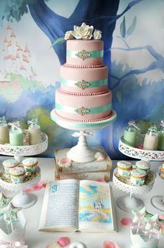 a table topped with lots of cakes and cupcakes