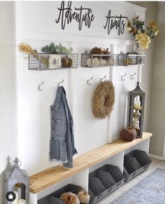 the entryway is decorated with hooks, baskets, and wreaths for fall decor