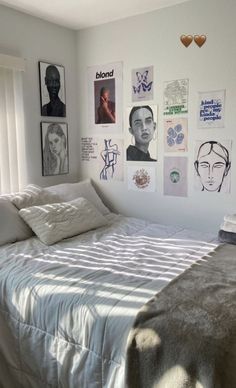 a bedroom with white walls and pictures on the wall