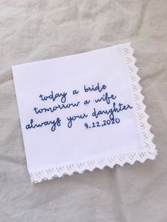 a white handkerchief with blue writing on it sitting on top of a tablecloth that says today is a bride tomorrow, a wife always you daughter always your daughter