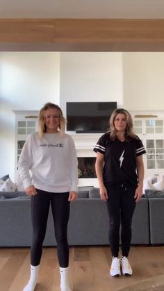 two women standing next to each other in a living room