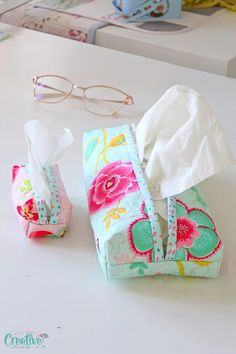 tissue and glasses sitting on a table next to some folded up tissues, napkins and eyeglasses