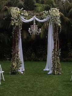 an outdoor wedding setup with white flowers and chandelier