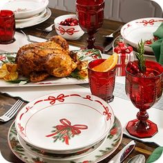 a table set for christmas dinner with turkey and cranberry garnishes