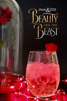 a pink drink in a wine glass with a red rose on the rim and an advertisement for beauty and the beast behind it