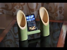 a cell phone sitting on top of a table next to two wooden speakers and a speaker system