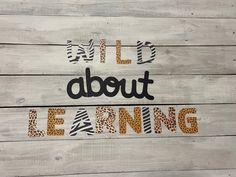 the words all about learning are painted on wood planks with zebra print and cheetah stripes