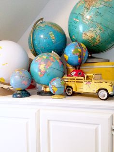 there is a toy truck and several globes on top of the dresser