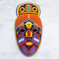 an embroidered mask is hanging on the wall