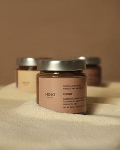 three jars of body butter sitting on top of a towel